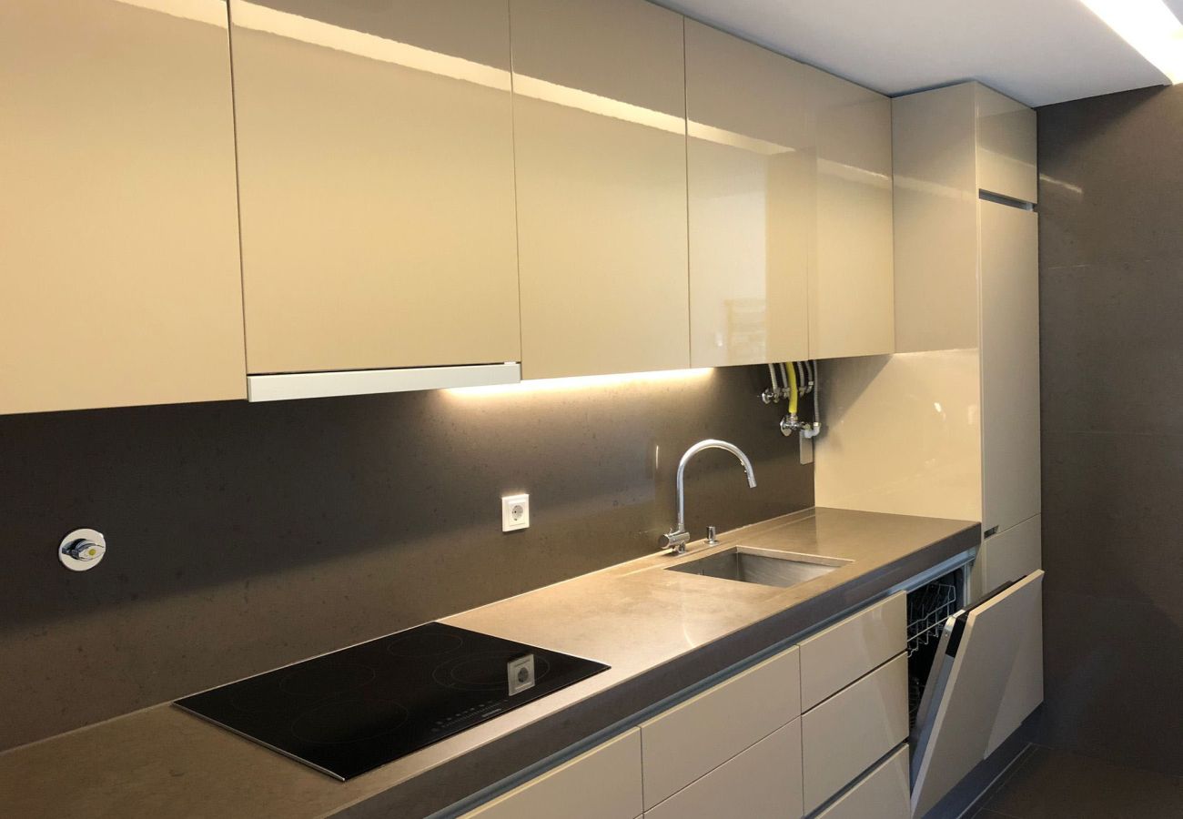 Kitchen equipped with elegant cabinets, built-in lighting, and a spacious countertop with integrated sink and stove.