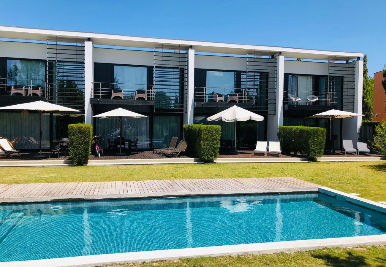 Contemporary facade with a crystal-clear blue pool and sun loungers around.