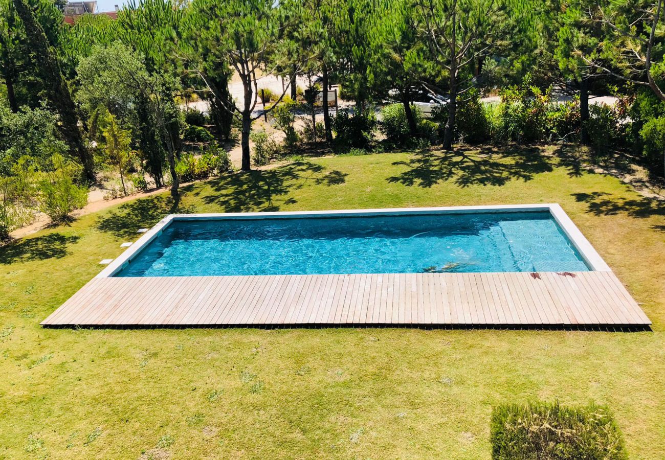 View from the balcony showcasing a crystal-clear pool and lush gardens, creating a relaxing atmosphere