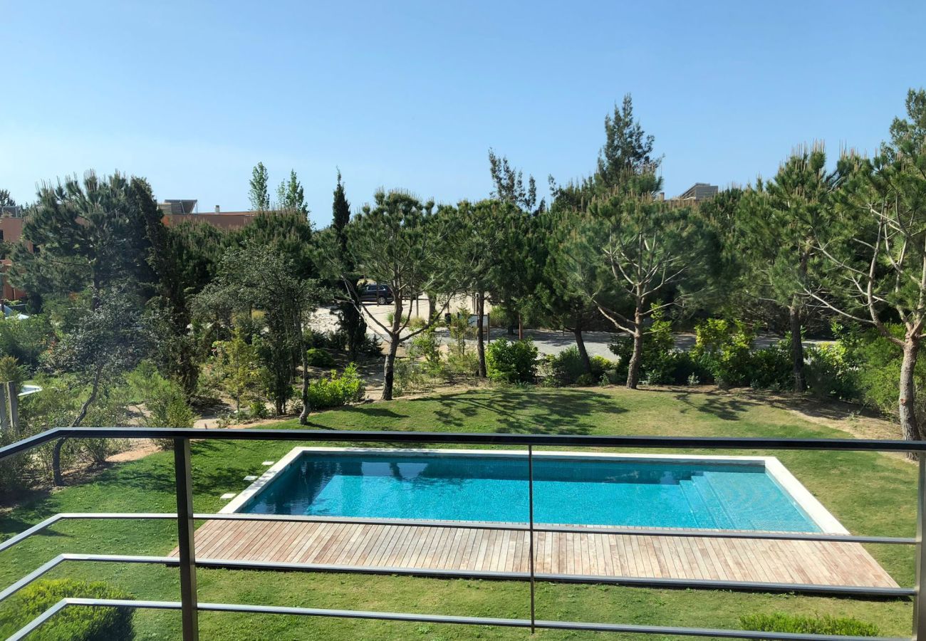 View from the balcony showcasing a crystal-clear pool and lush gardens, creating a relaxing atmosphere.