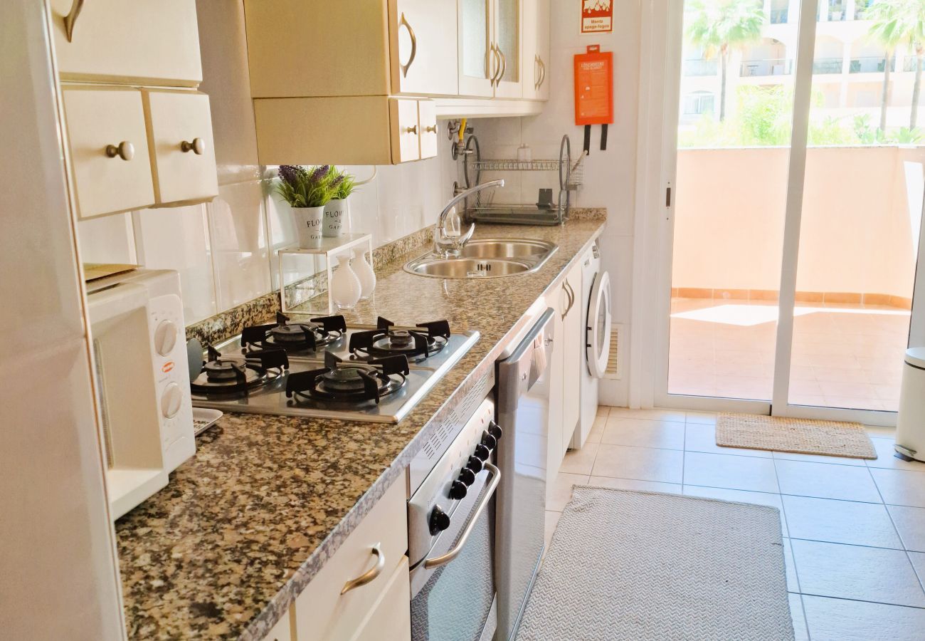 Modern and functional kitchen with a granite countertop, white cabinets, and access to the balcony overlooking the outdoors.