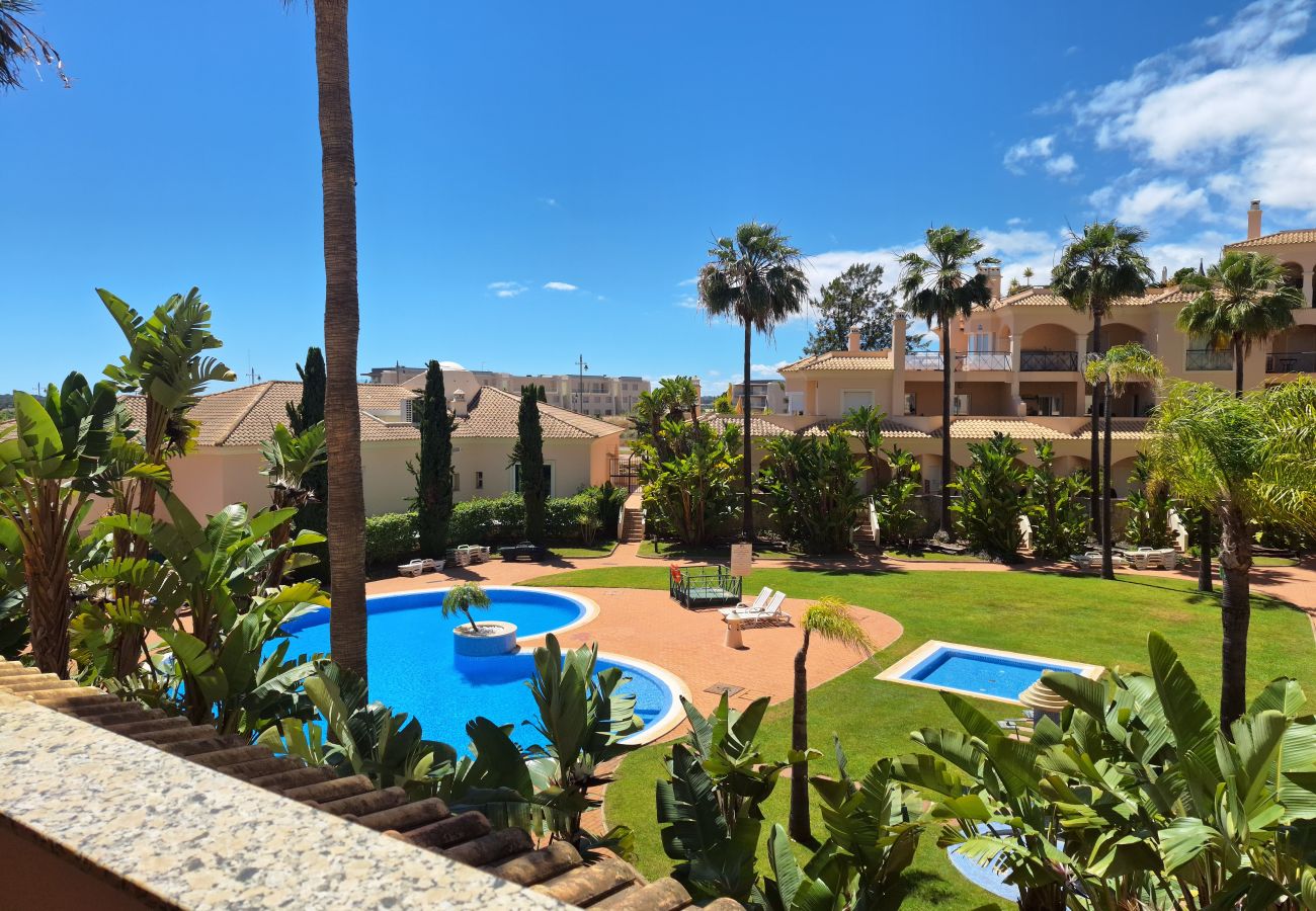 Stunning balcony view of the pool, surrounded by tropical gardens and elegant buildings.