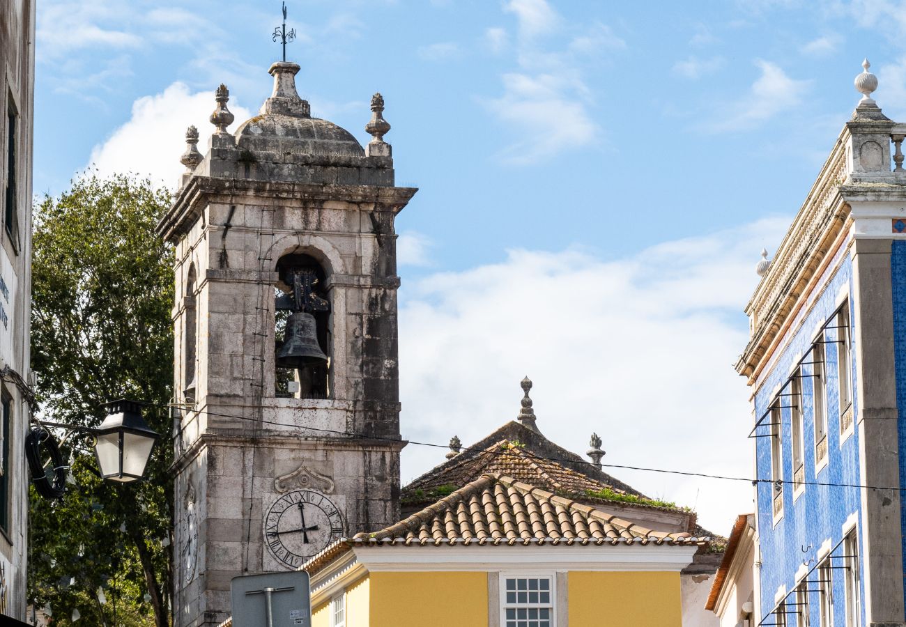 View of Sintra with its colorful houses, surrounded by green hills and lush trees.