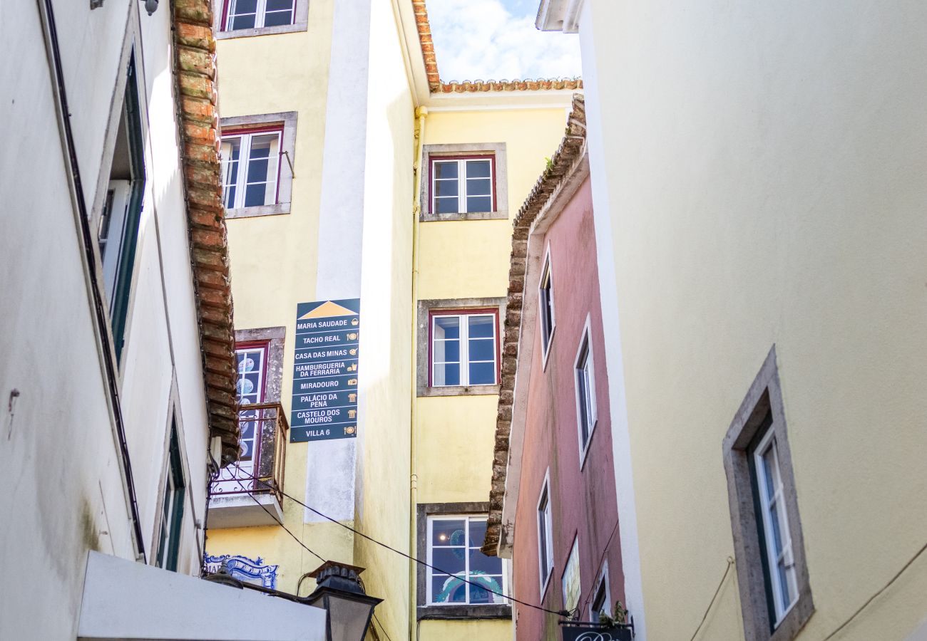 Picturesque narrow street in Sintra, surrounded by colorful buildings, shops, and traditional signs.