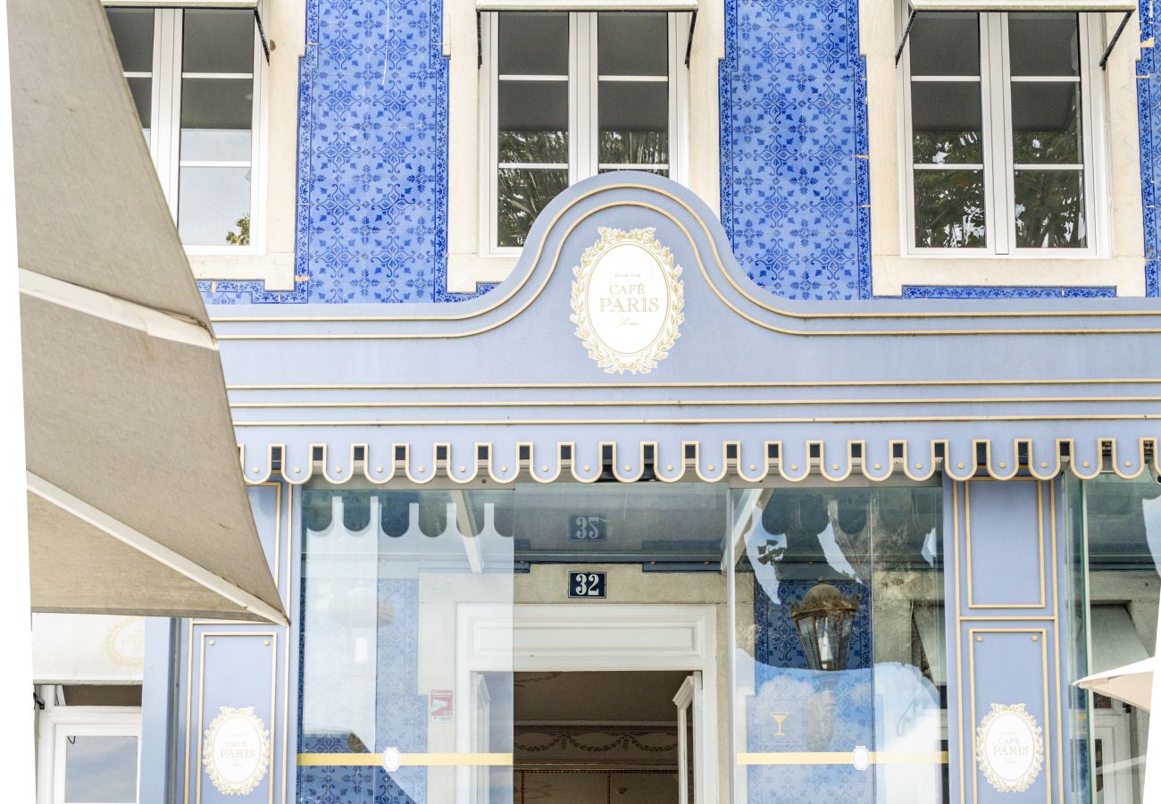 Historic blue building with white windows and a charming entrance with an awning.