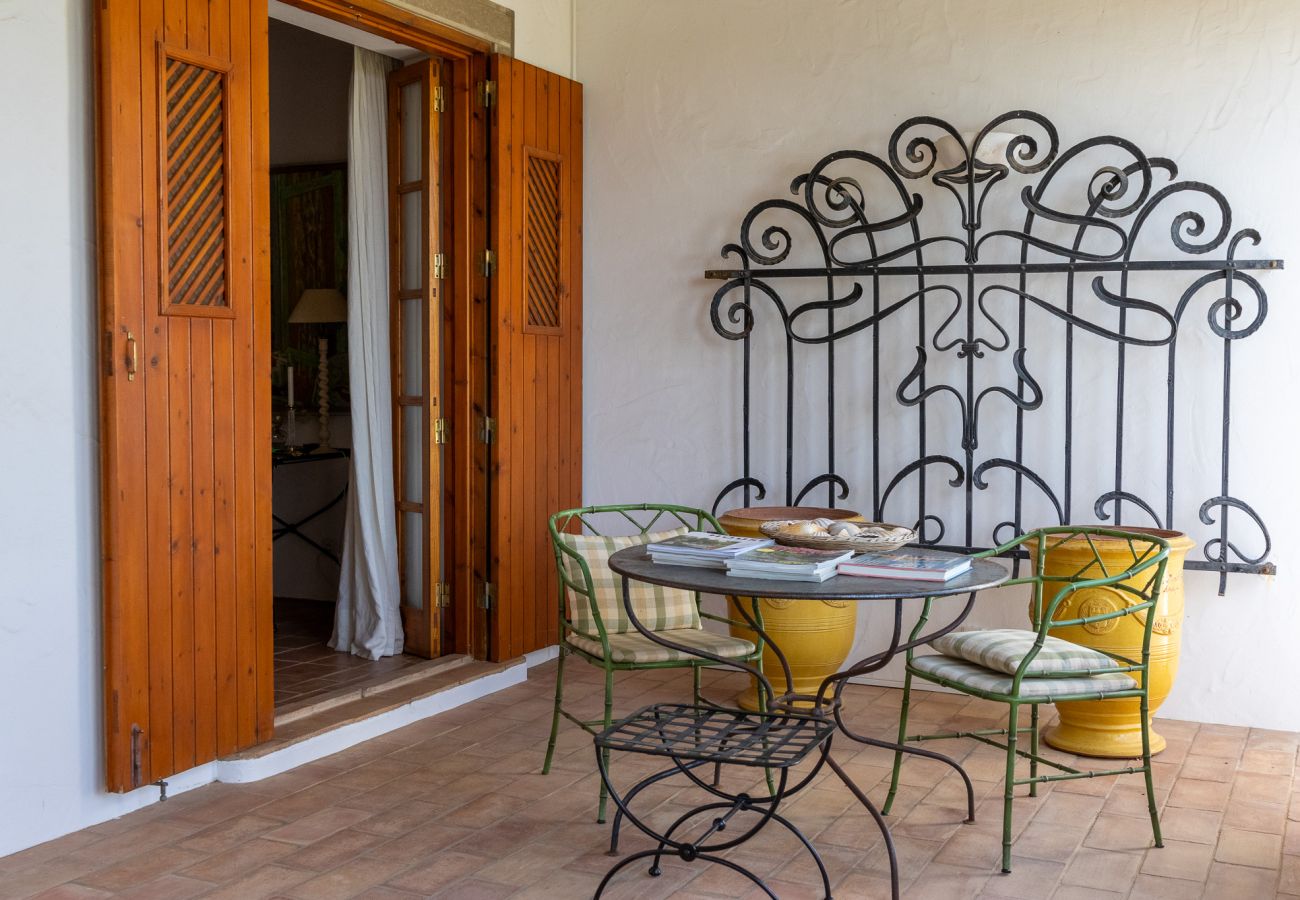 Outdoor space in the villa in Almancil, featuring a wrought iron table and chairs next to the wooden door.