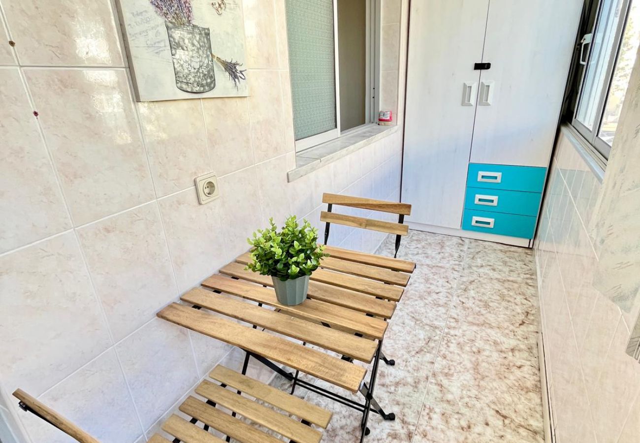 Small enclosed terrace featuring a wooden table and chairs, lavender painting decoration, and storage cabinets.