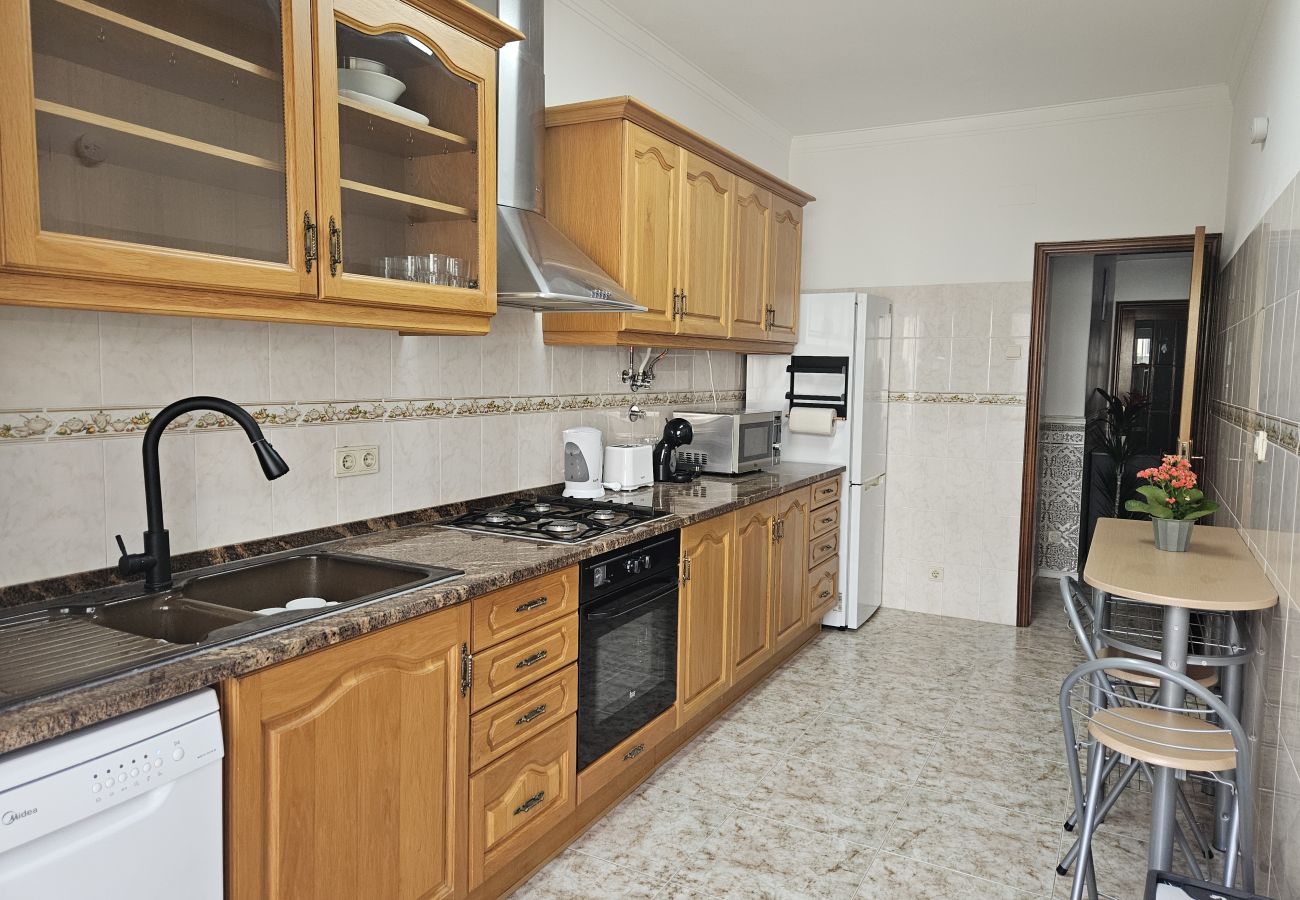 Spacious kitchen featuring wooden cabinets, granite countertops, built-in stove, table with chairs, and cozy decor.