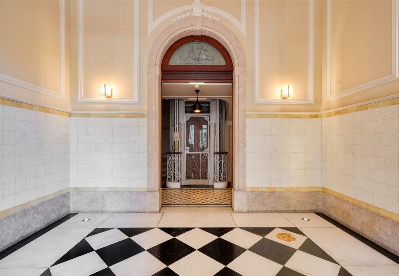 Entrance hall of the building featuring historical architectural details and a stylish vintage elevator.