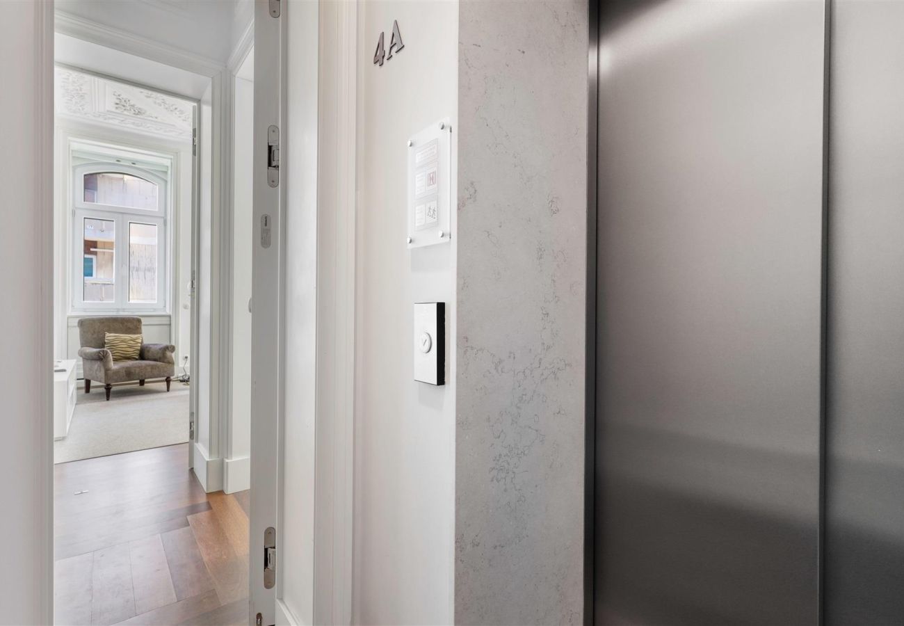 Apartment entrance with direct access via private elevator, featuring a modern hallway and the living room in the background.